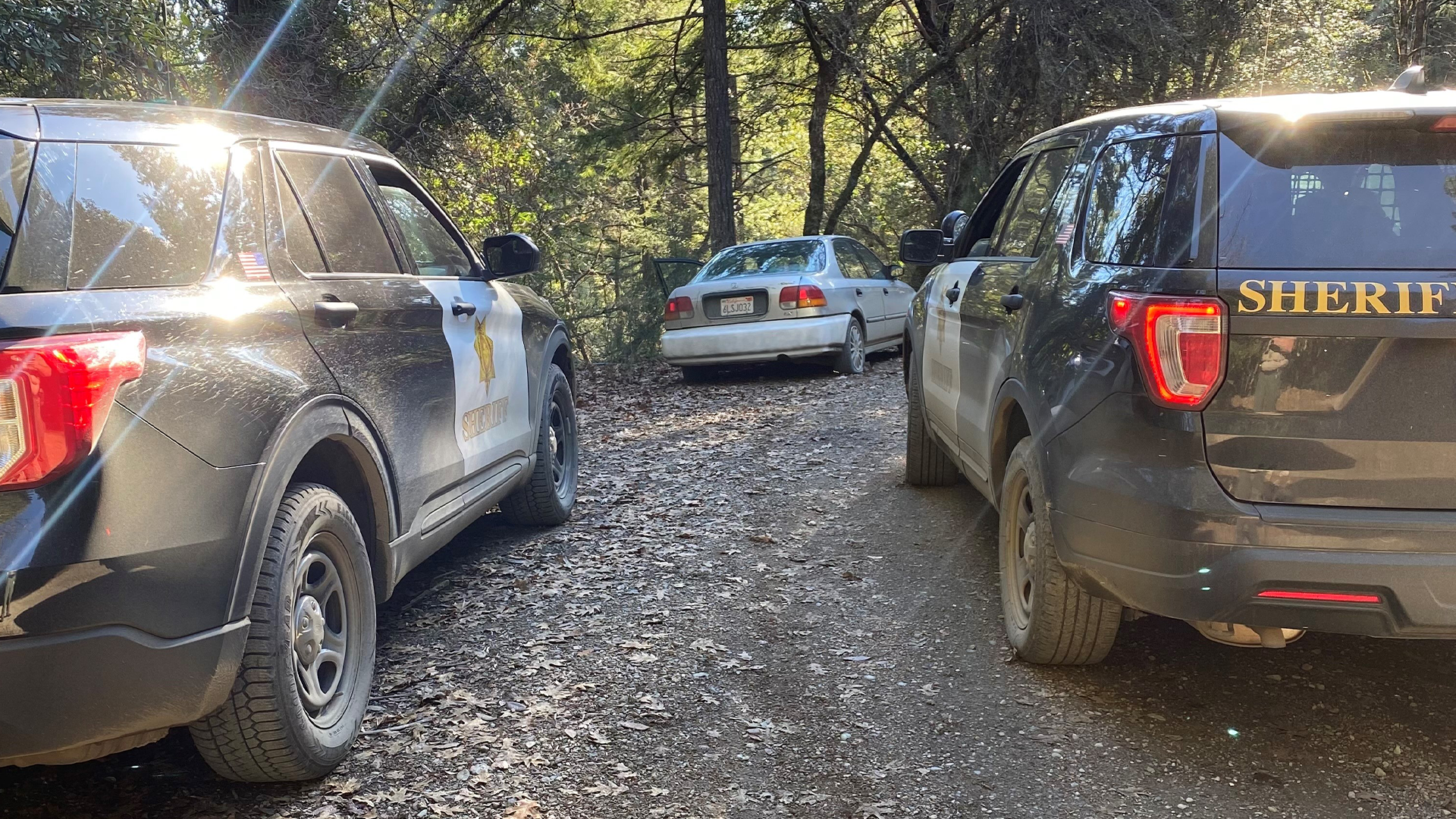 Two Sheriff patrol cars behind a stolen vehicle. 