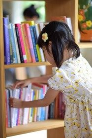 A young girl choosing books.