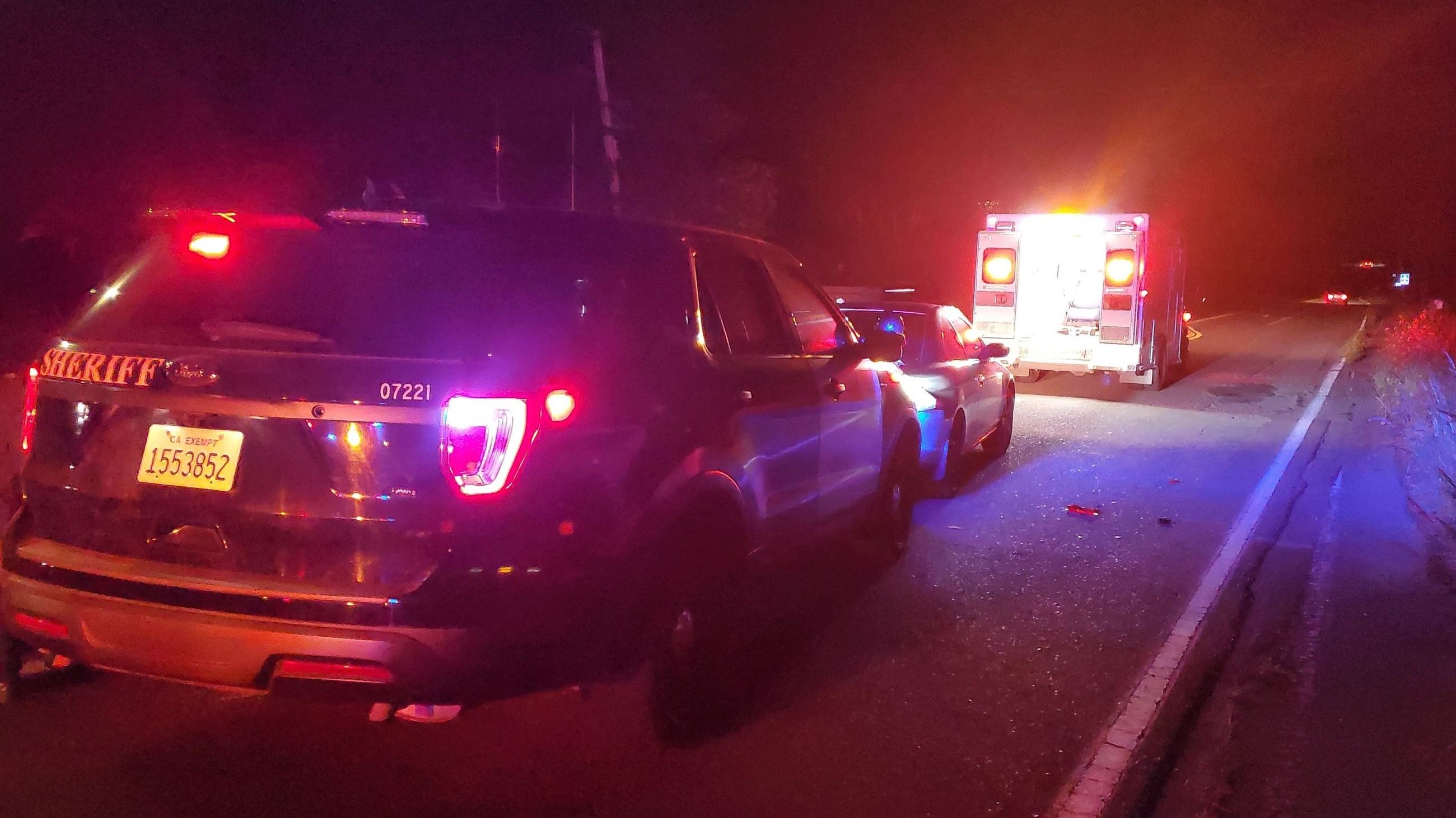 Emergency vehicles and a suspect vehicle on the roadway at night