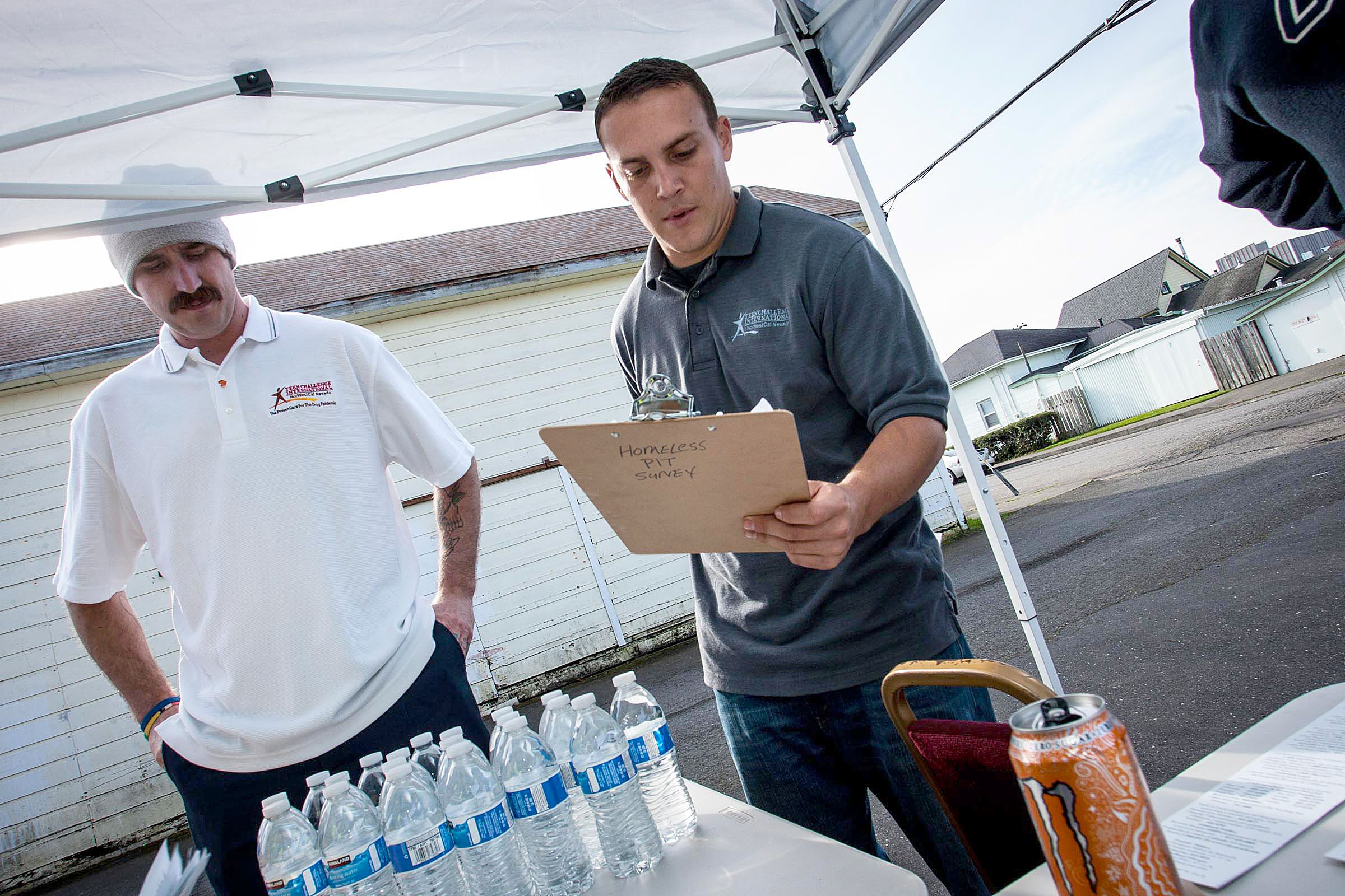 Two Teen Challenge volunteers deliver forms for processing.