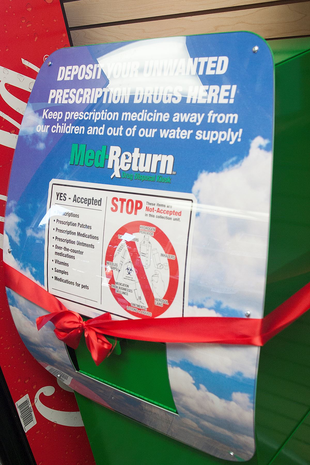 A new medication disposal bin wrapped with a red ribbon.