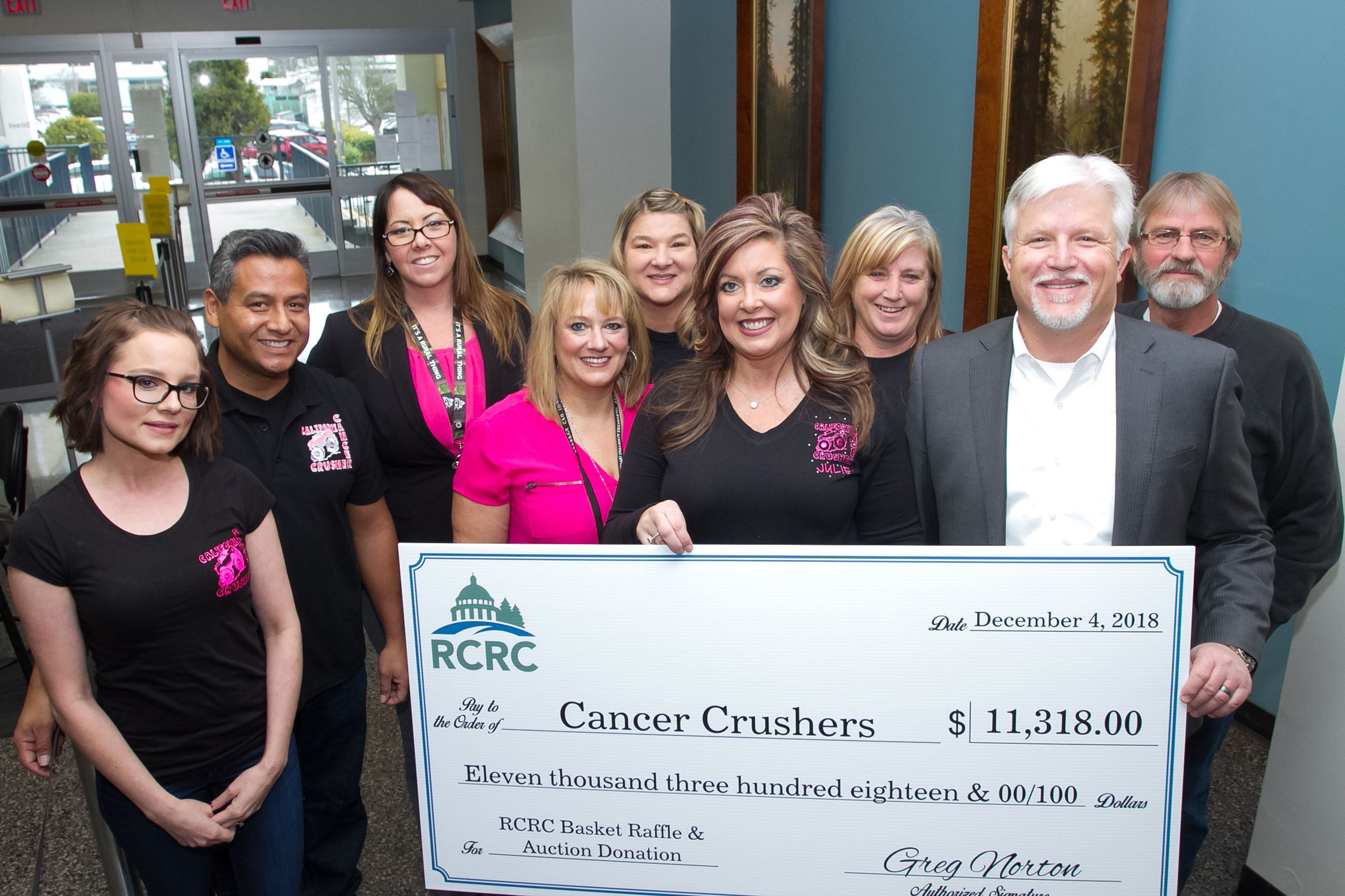 RCRC Chief Executive Officer, front right, presents a check for $11,318 to the Cancer Crushers.