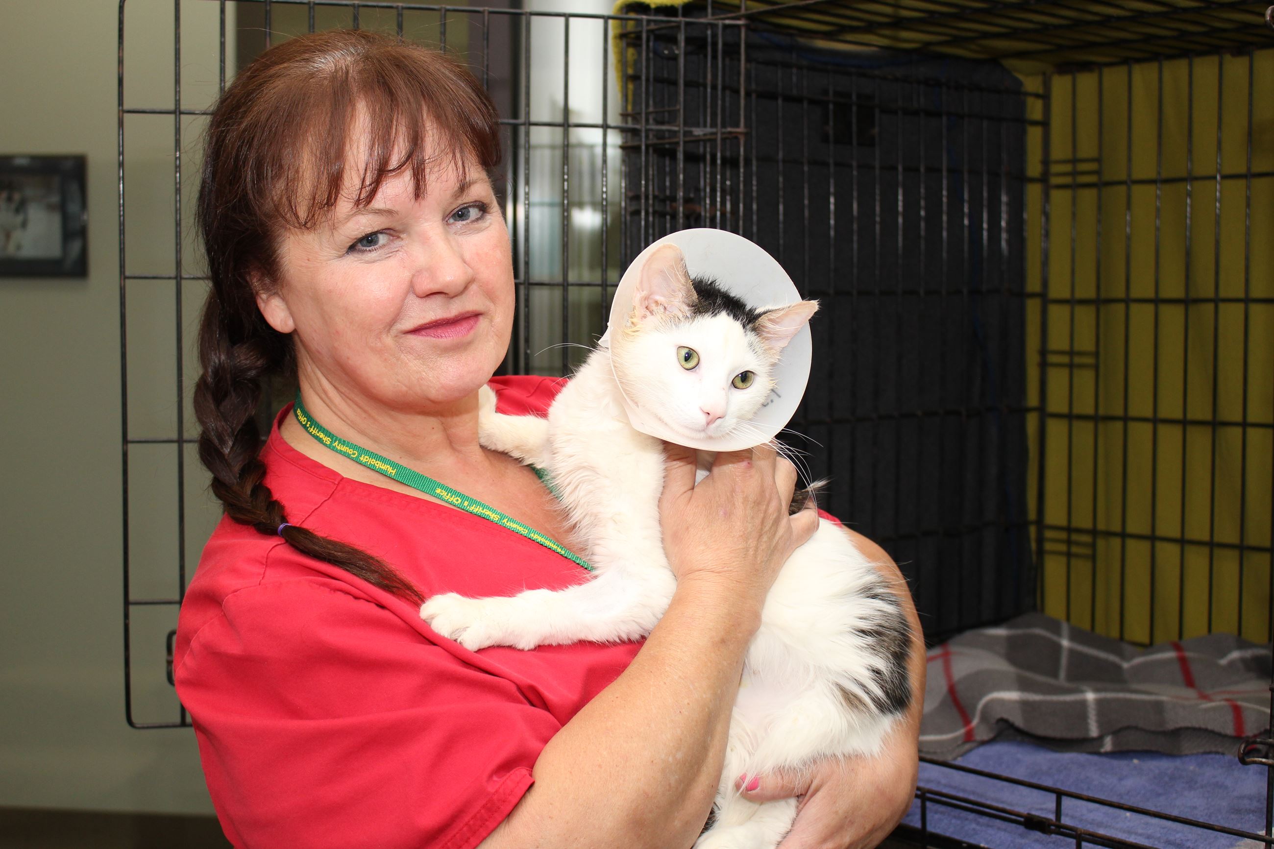 Female Animal Shelter Attendant holds a Cat