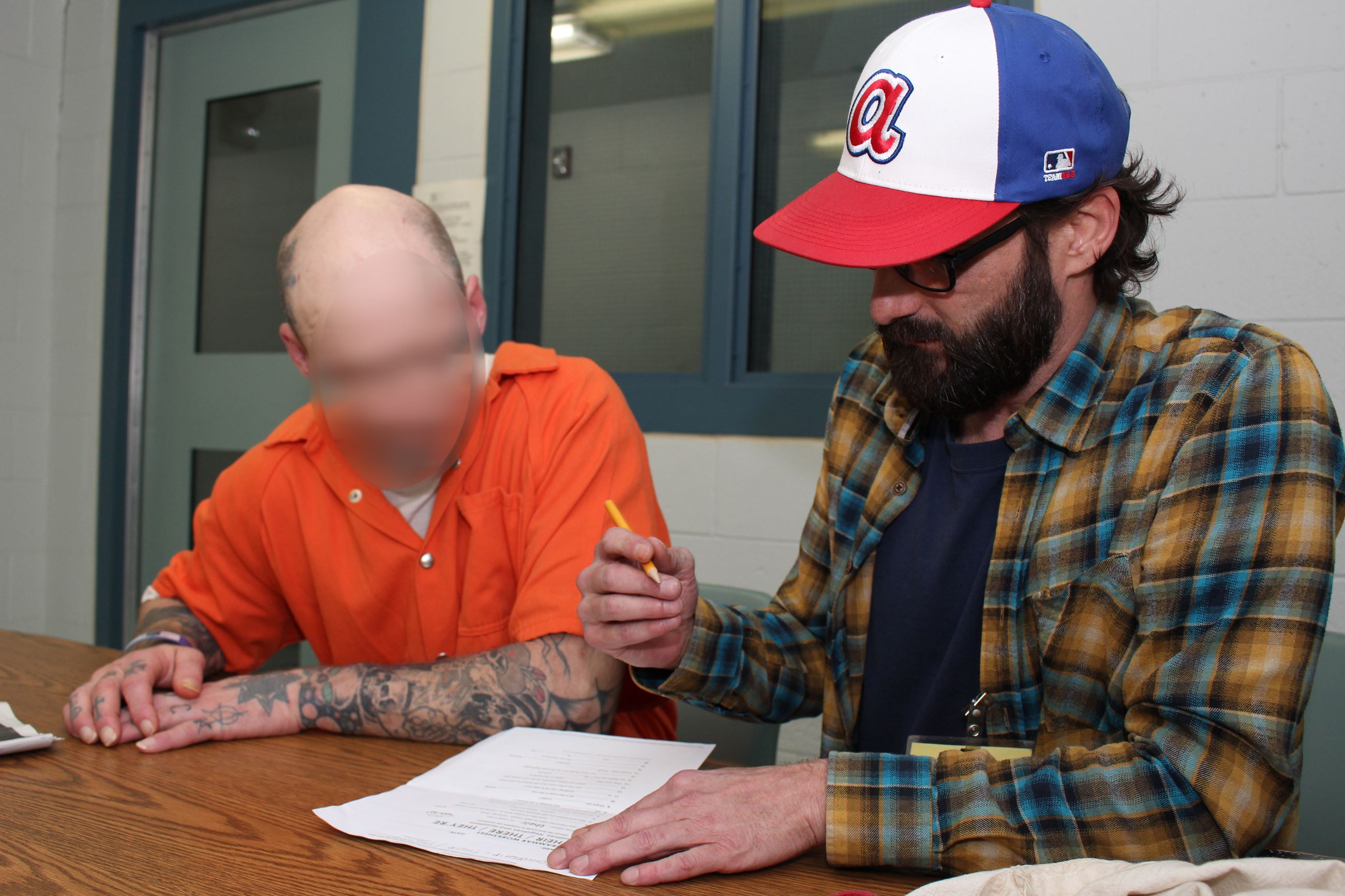 A male inmate meets with a male volunteer