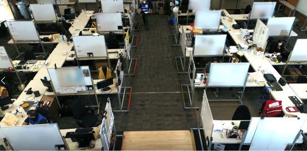 Large, open room with many desks and whiteboards